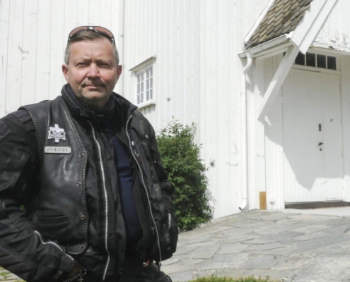 Bilde av Gjermund Kristensen i MC-klær foran kirken.